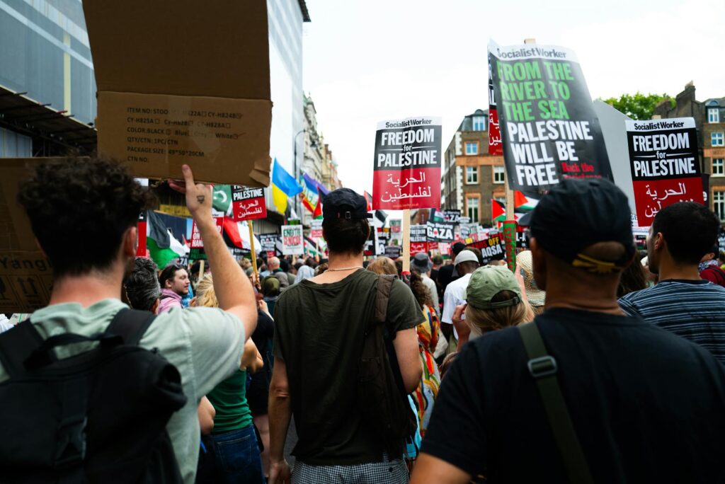 Crowd in London protesting for Palestine, holding signs advocating freedom and rights.