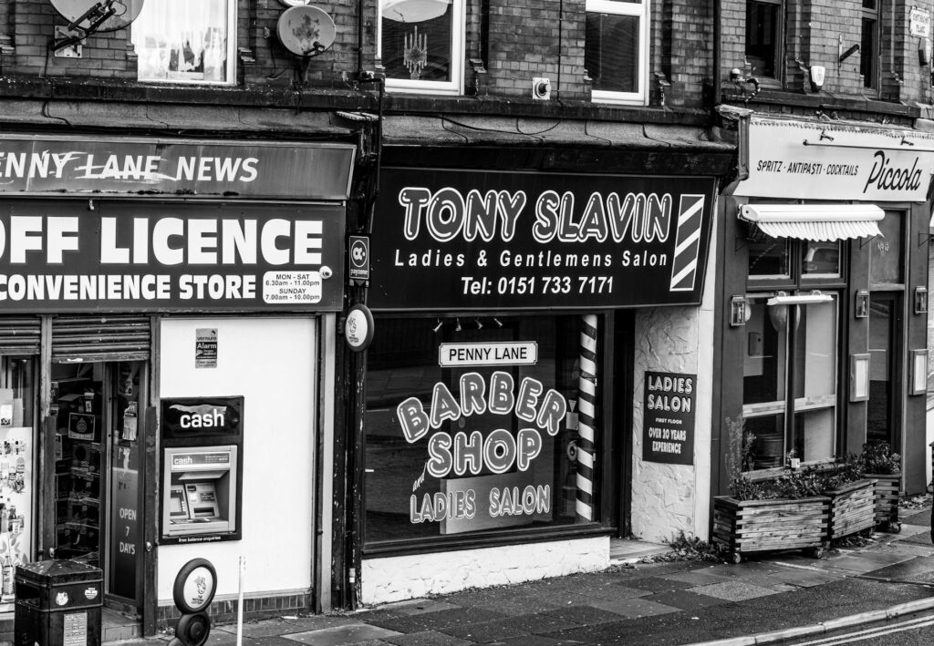 Black and white street view of Tony Slavin Barber Shop in Liverpool's Penny Lane.
