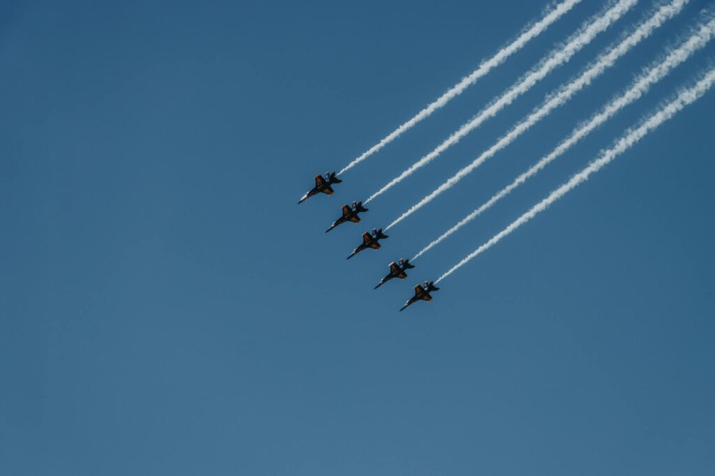 Navy's Blue Angels performing aerial stunts in a clear sky.