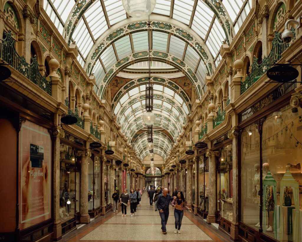 Stunning Victorian architecture with arched glass ceiling in a bustling Leeds arcade.