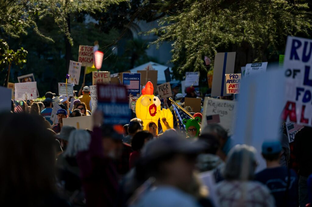 A vibrant protest scene capturing various signs and symbols in downtown Sacramento.
