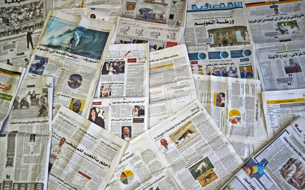 A variety of Arabic newspapers laid out, showcasing cultural and news diversity in Fès, Morocco.