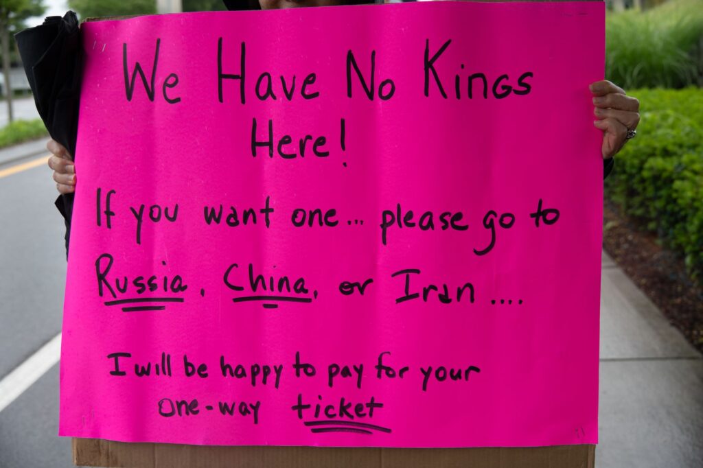 A vibrant protest sign in South Kingstown, Rhode Island, advocating against monarchies with political messaging.