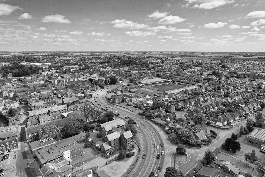 Black and white aerial view of Boston, Lincolnshire with roads and buildings under a cloudy sky.