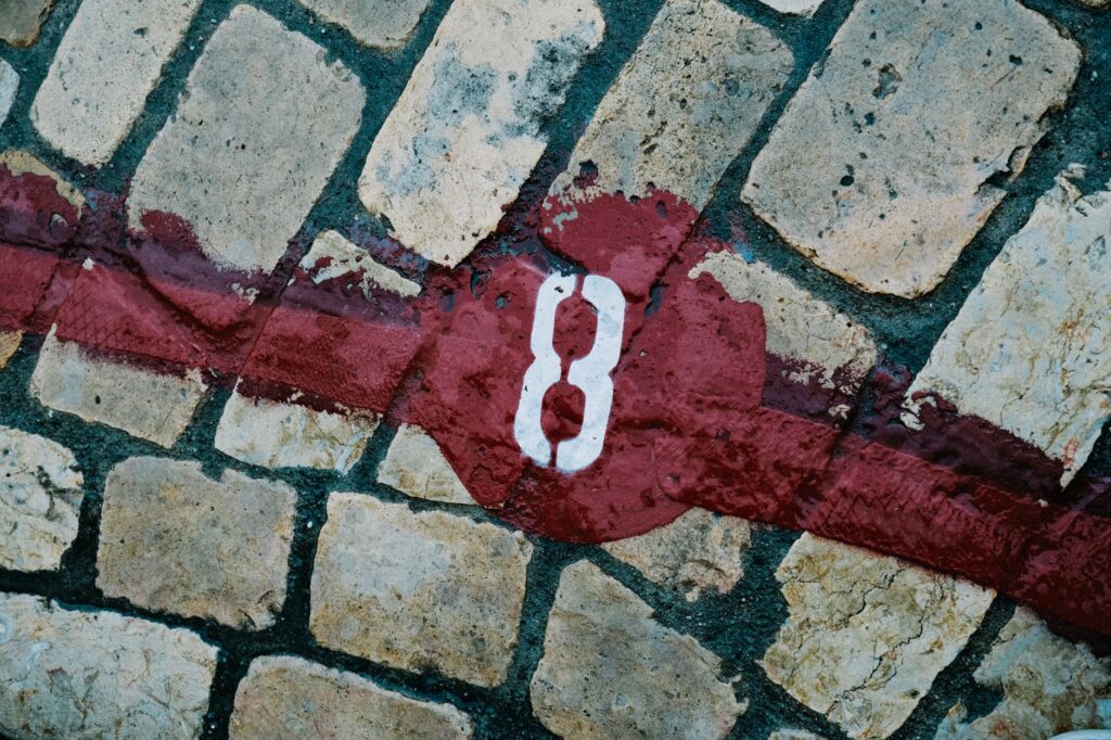 Close-up of a number 8 painted on cobblestone pavement, artistic texture.